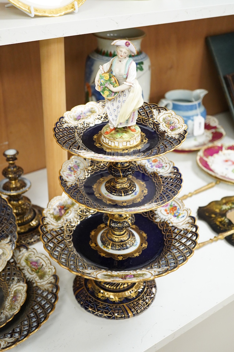 A pair of late 19th century Meissen three tier cake stands with figural tops, 48cm high